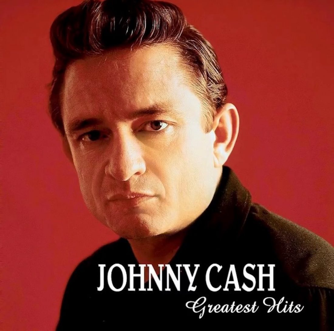 Johnny Cash looks at the camera in front of a red background